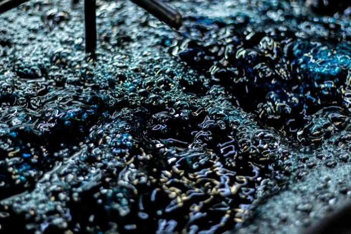 Close-up of dark blue liquid with bubbles.